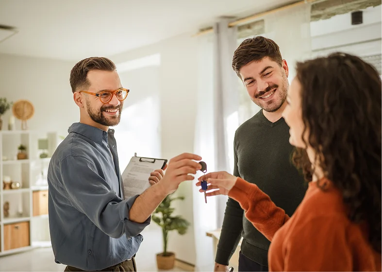 Smiling agent gives keys to new homeowners